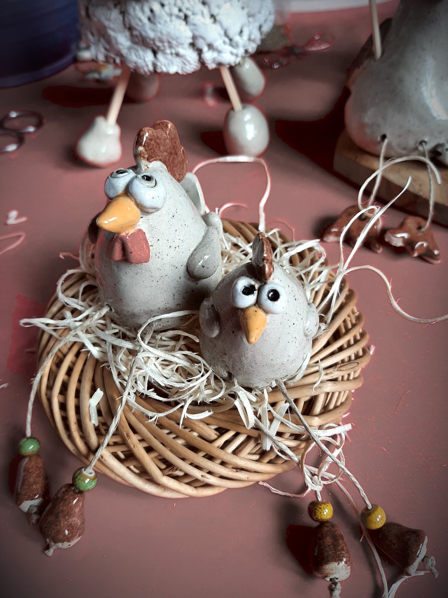 Deux poules en grès installées dans un nid d'osier