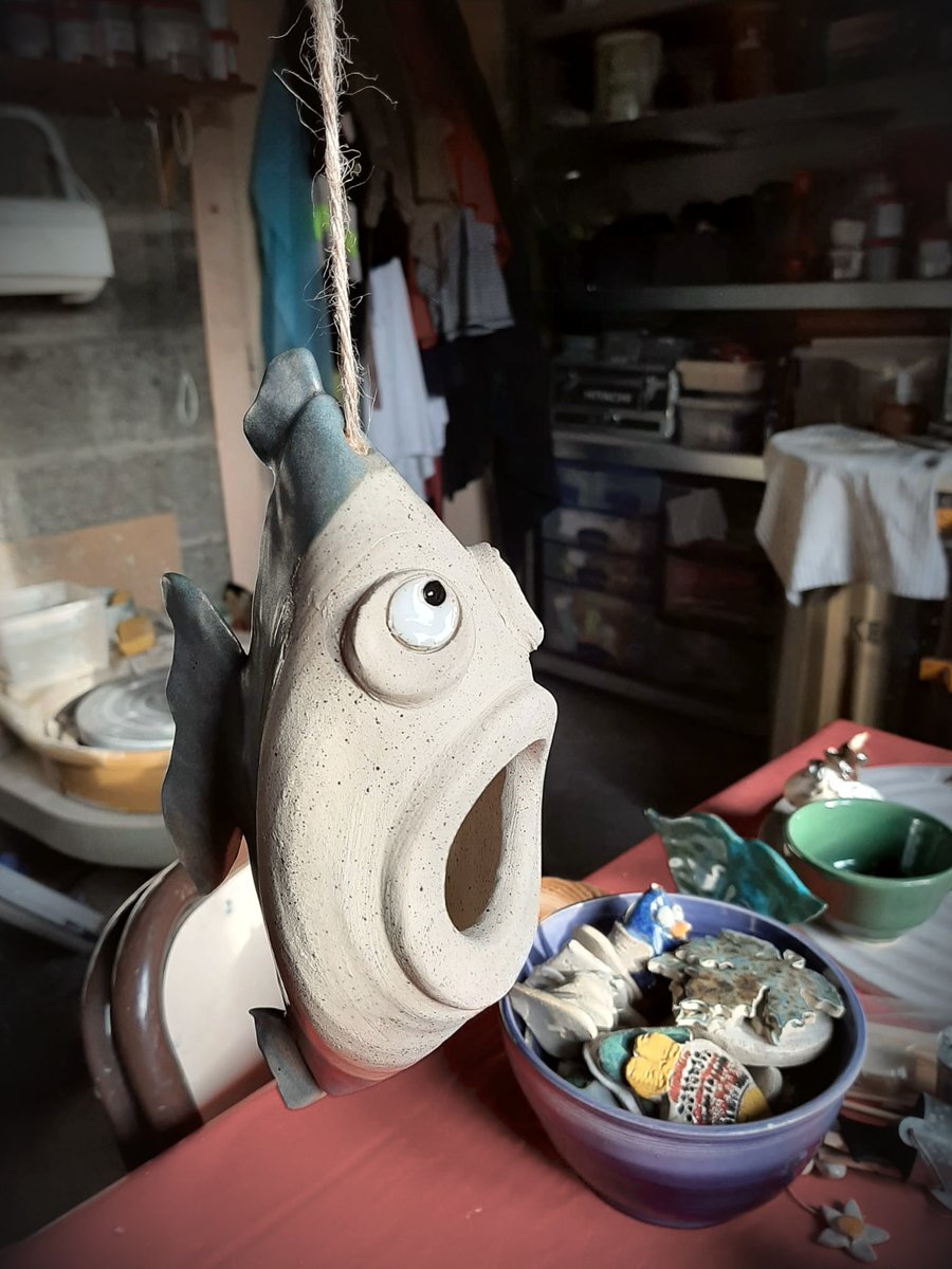 Poisson en grès suspendu à une ficelle, la bouche grande ouverte