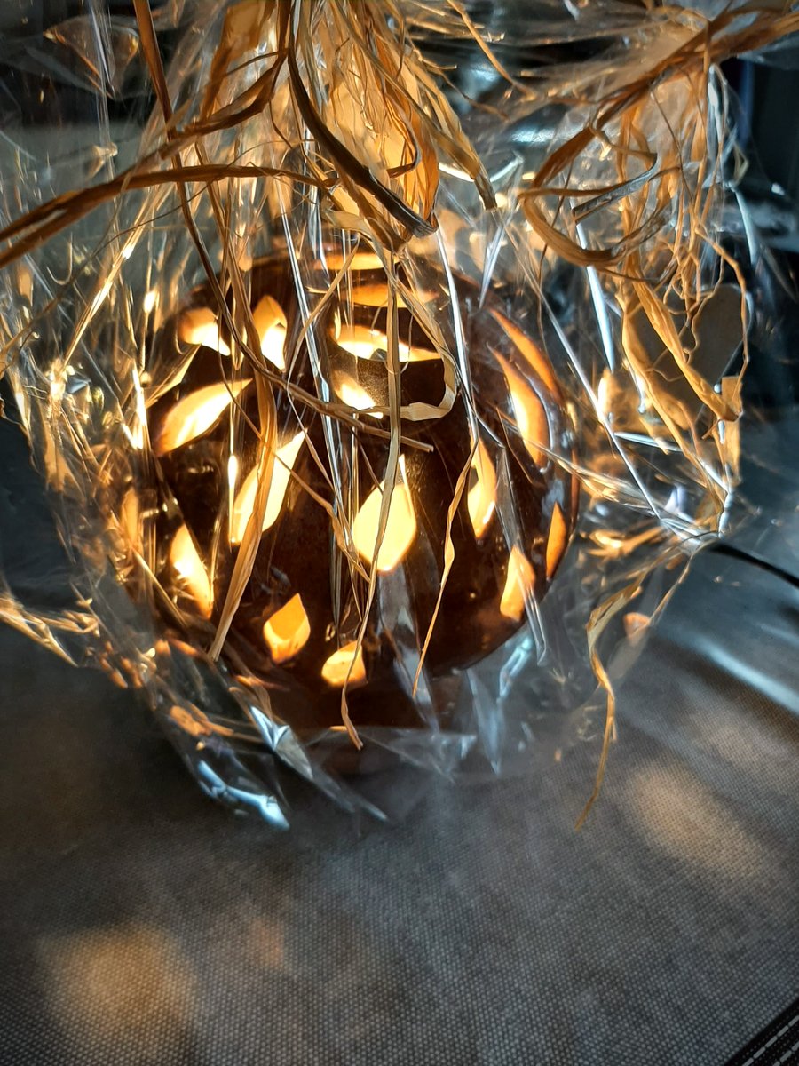 Détail de la lanterne en grès, la flamme révélant le motif de feuilles